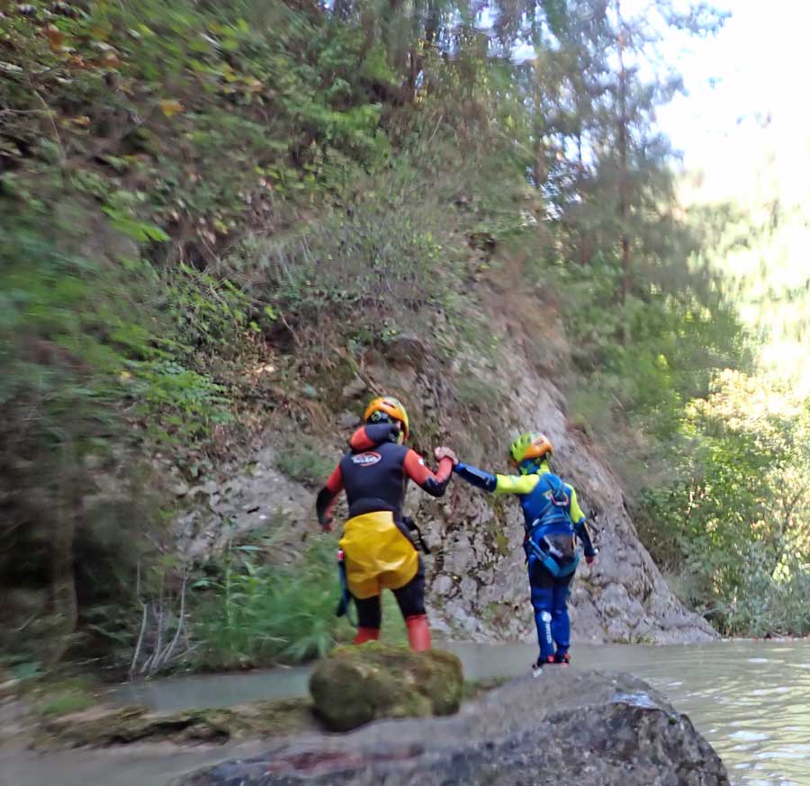 Família amb equip de seguretat preparant-se per començar una aventura de trekking aqüàtic en un entorn natural